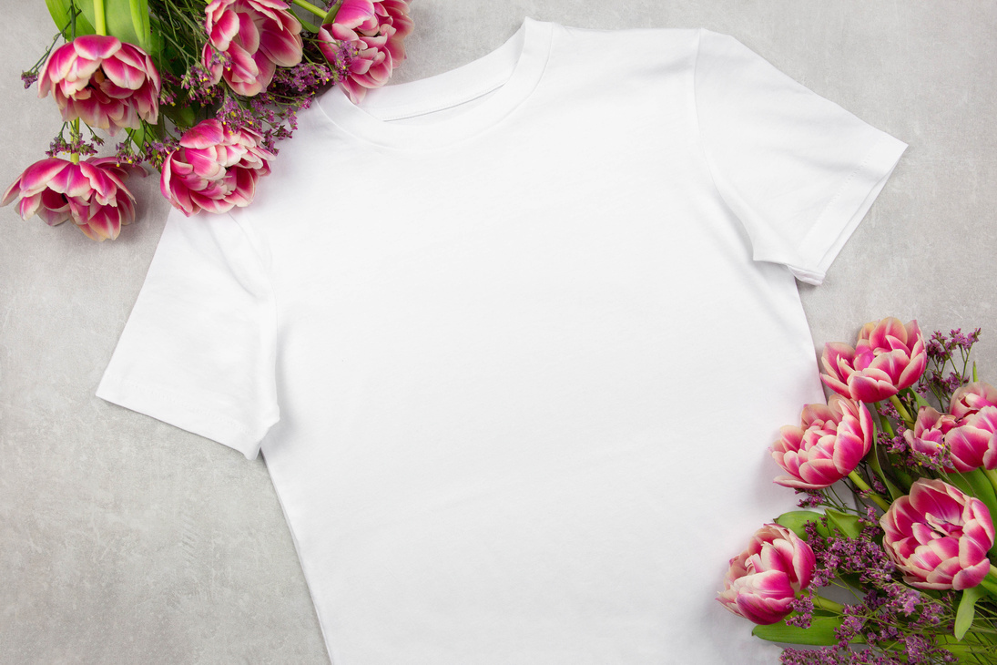 White Womens Cotton T-Shirt Mockup with Pink Tulips Flowers on Gray Concrete Background. Design T Shirt Template, Print Presentation Mock up. Top View Flat Lay.